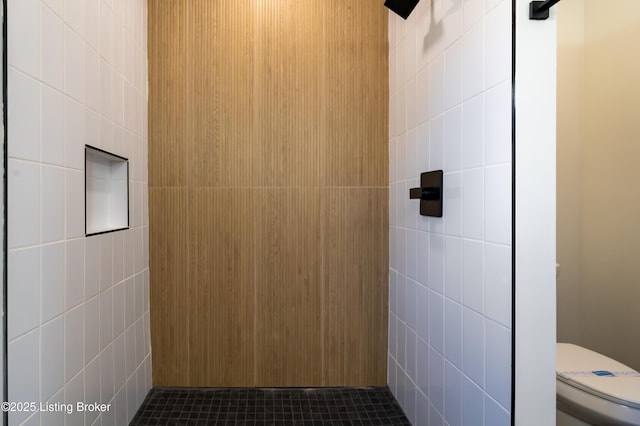 bathroom featuring tile walls and toilet