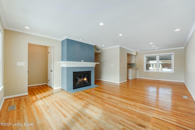 unfurnished living room with light wood-style flooring, a brick fireplace, visible vents, and baseboards