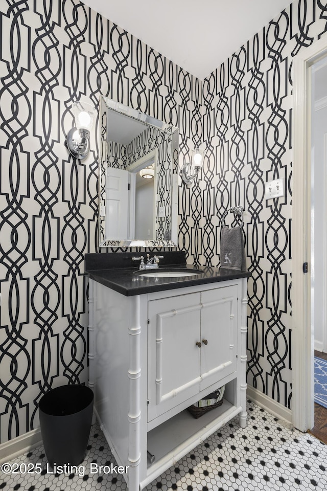 bathroom with baseboards, tile patterned flooring, vanity, and wallpapered walls