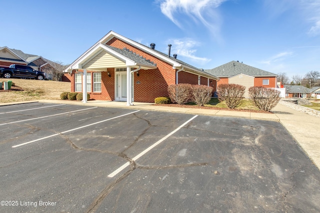 view of front of property featuring uncovered parking and brick siding