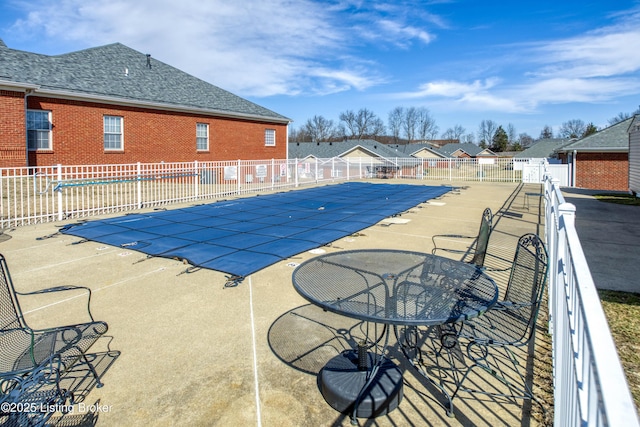 pool with a residential view, a patio area, and fence