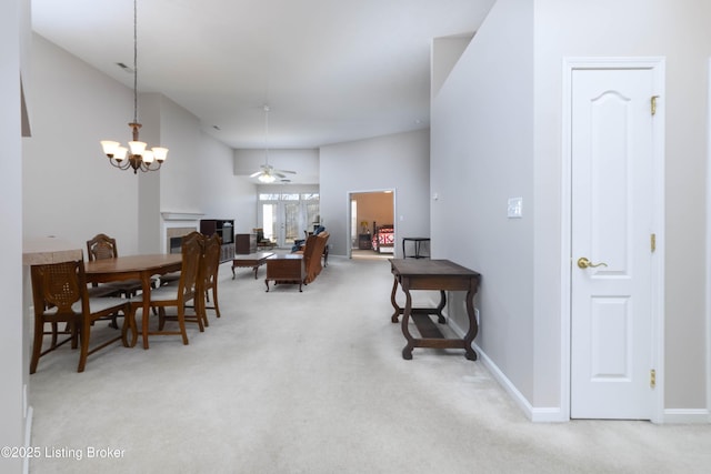 dining room with carpet floors, baseboards, a tiled fireplace, and a ceiling fan