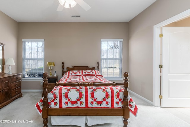 bedroom featuring baseboards, multiple windows, visible vents, and light colored carpet