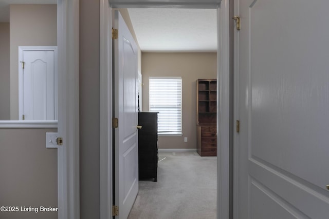 corridor with light carpet and baseboards