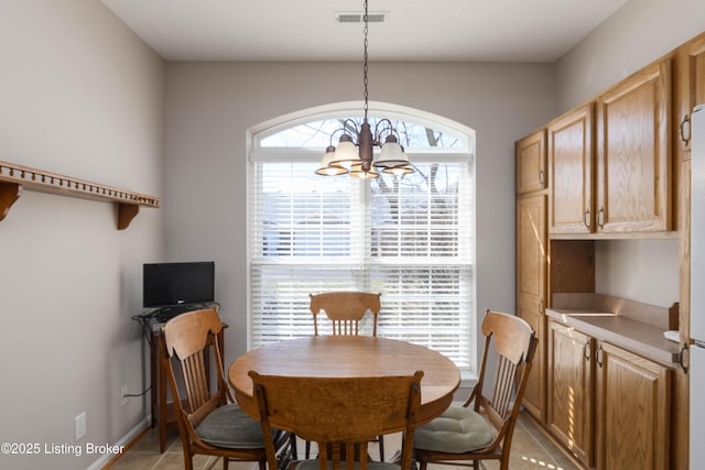 dining space with light tile patterned floors, visible vents, baseboards, and an inviting chandelier