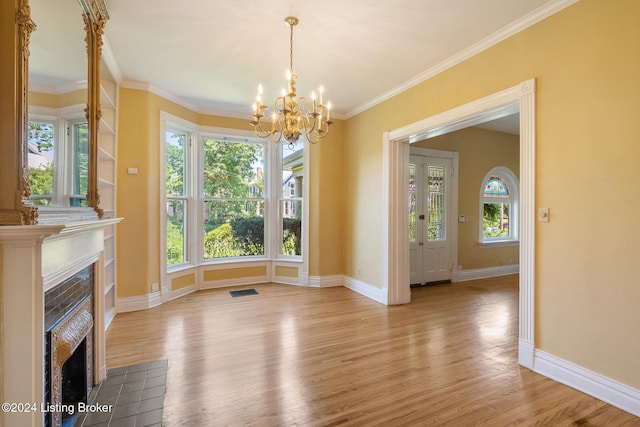 unfurnished dining area with a fireplace with flush hearth, ornamental molding, light wood-style flooring, and baseboards