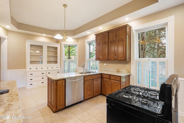 kitchen with black gas range oven, brown cabinets, a peninsula, hanging light fixtures, and stainless steel dishwasher