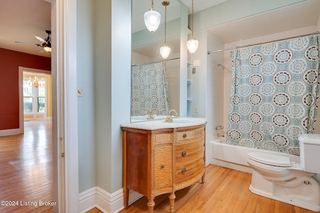 bathroom with toilet, wood finished floors, vanity, a ceiling fan, and shower / bath combo with shower curtain