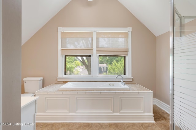 full bath featuring lofted ceiling, a garden tub, vanity, and toilet