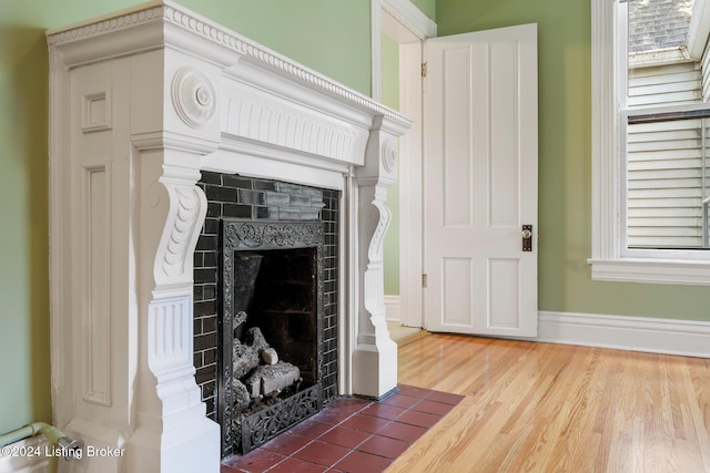 details with a fireplace, wood finished floors, and baseboards