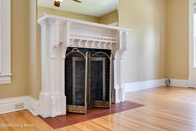 interior details featuring baseboards, wood finished floors, and a tile fireplace