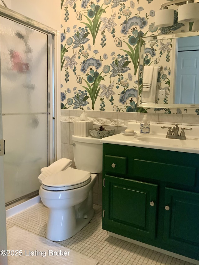 bathroom featuring wallpapered walls, a shower stall, tile patterned floors, and vanity