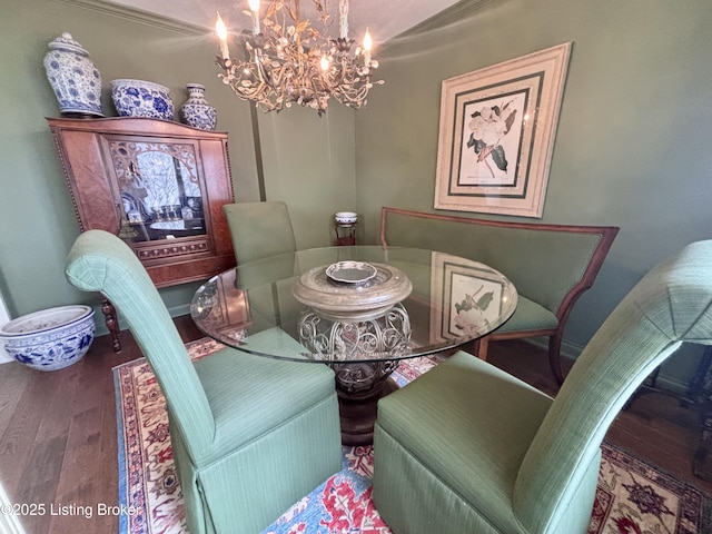 dining room featuring an inviting chandelier, baseboards, and wood finished floors