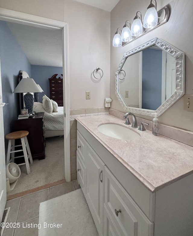 ensuite bathroom with tile patterned flooring, ensuite bath, and vanity