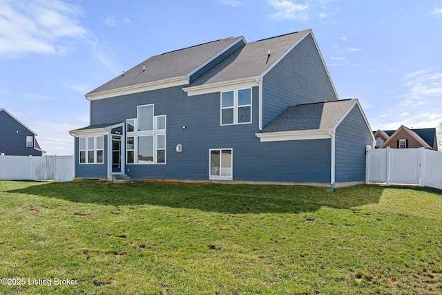 back of house featuring a fenced backyard, a yard, and roof with shingles