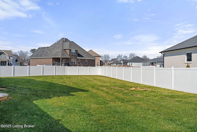 view of yard featuring fence and a residential view