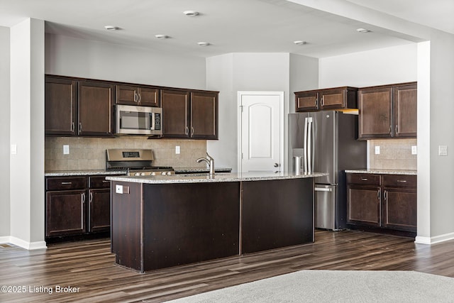 kitchen with dark brown cabinets, appliances with stainless steel finishes, dark wood-style flooring, and a sink