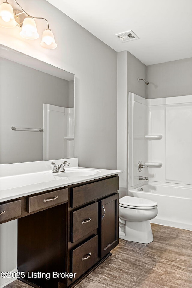 full bathroom featuring shower / bathtub combination, visible vents, toilet, vanity, and wood finished floors