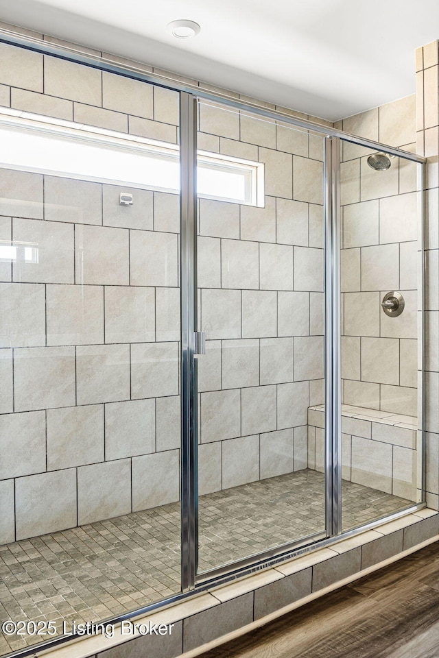 bathroom with a shower stall and wood finished floors