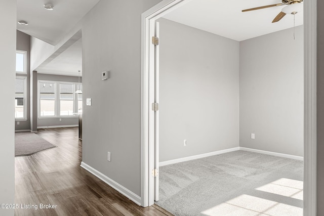 hall with wood finished floors and baseboards