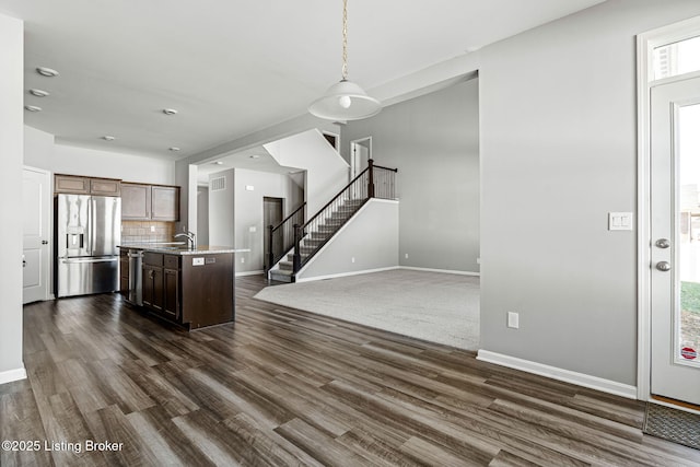 kitchen featuring dark wood-style flooring, stainless steel appliances, tasteful backsplash, open floor plan, and a sink