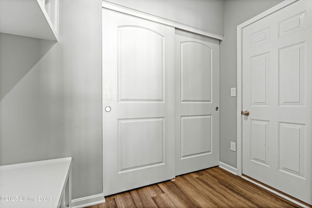 foyer entrance with dark wood-style floors and baseboards