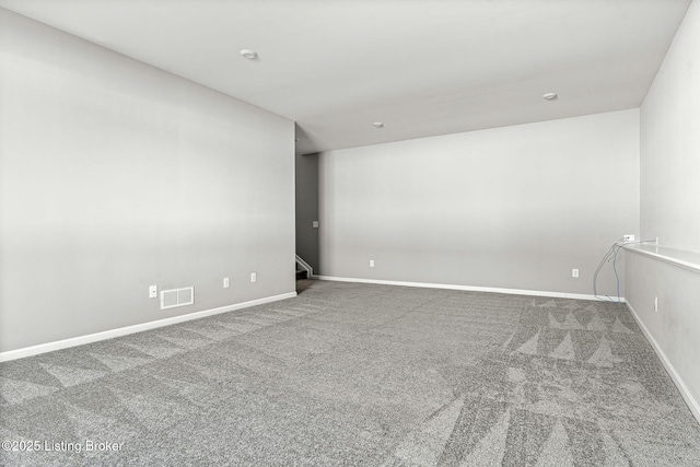 empty room featuring carpet, visible vents, and baseboards