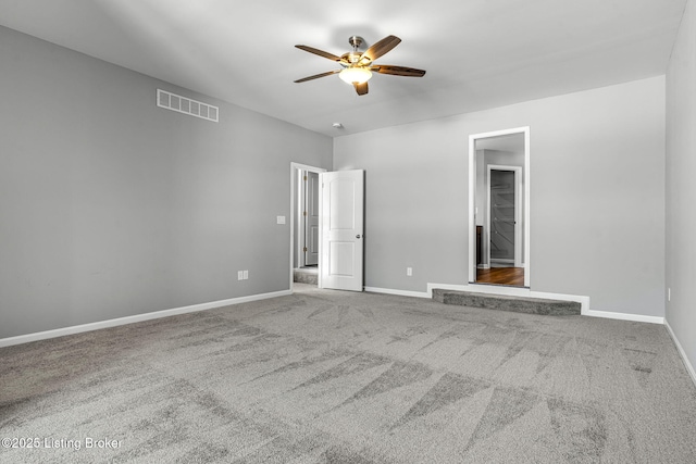 unfurnished bedroom featuring a ceiling fan, carpet flooring, visible vents, and baseboards