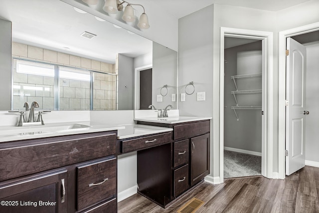 full bathroom with visible vents, a shower stall, vanity, and wood finished floors