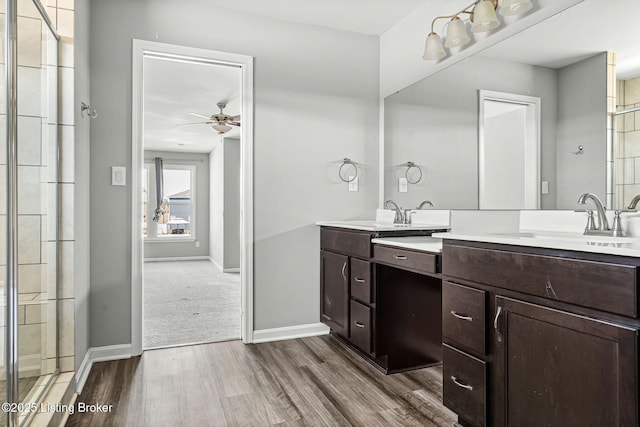 full bath featuring baseboards, a sink, and wood finished floors