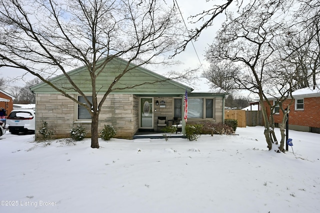 view of front facade with stone siding and fence