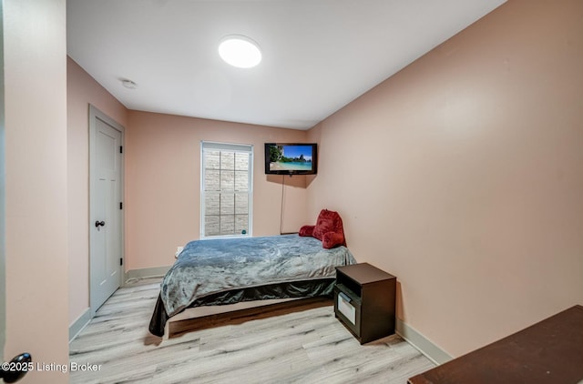 bedroom featuring baseboards and wood finished floors