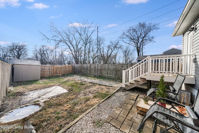 view of yard featuring a fenced backyard, stairs, a wooden deck, and an outbuilding