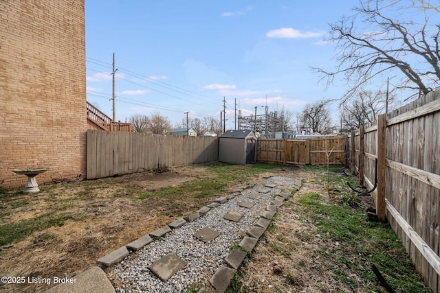 view of yard featuring a fenced backyard, a storage unit, and an outdoor structure