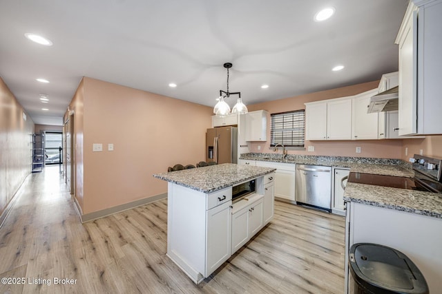 kitchen featuring light wood-style flooring, recessed lighting, under cabinet range hood, appliances with stainless steel finishes, and a center island