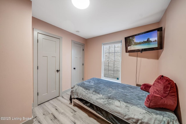 bedroom featuring baseboards and wood finished floors