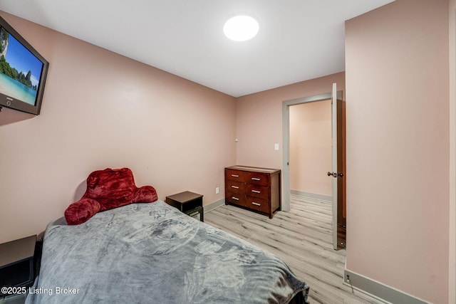 bedroom featuring light wood-style floors and baseboards