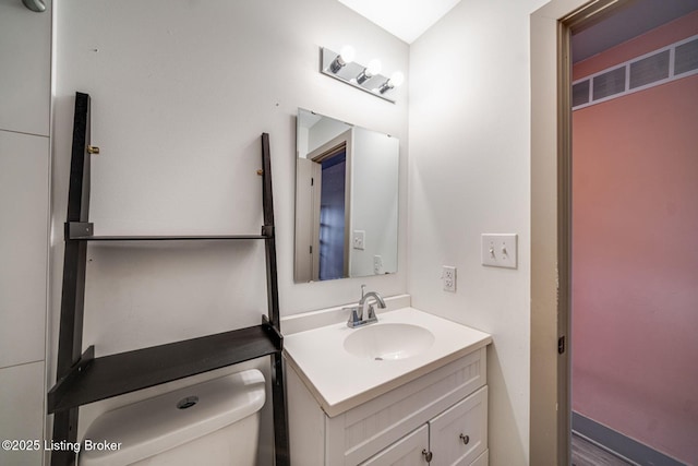 half bathroom featuring toilet and vanity