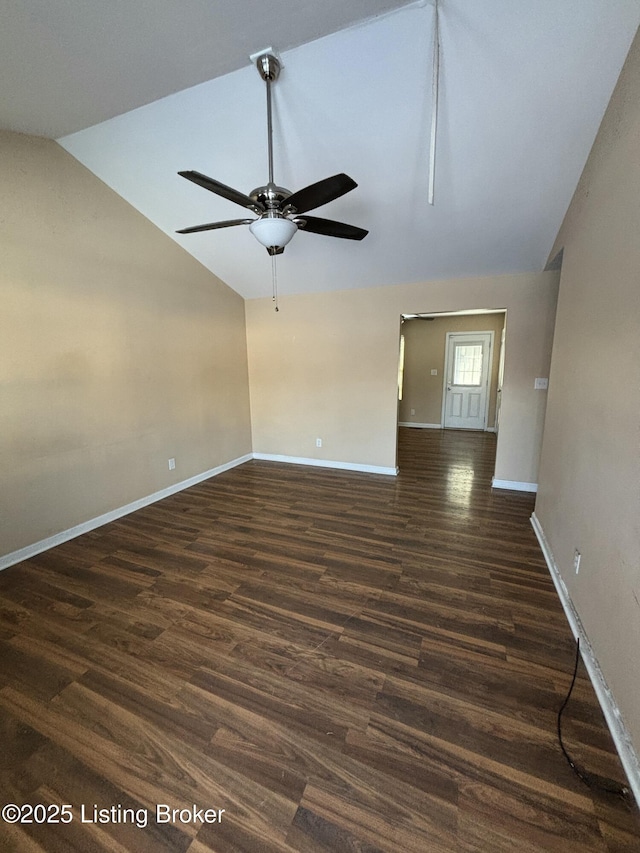 empty room featuring lofted ceiling, dark wood-style flooring, and baseboards