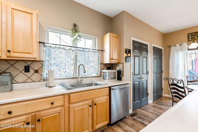 kitchen featuring a sink, light wood-style floors, light countertops, and stainless steel dishwasher