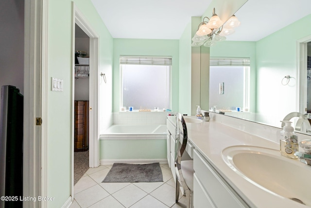 bathroom with a garden tub, tile patterned flooring, an inviting chandelier, and vanity