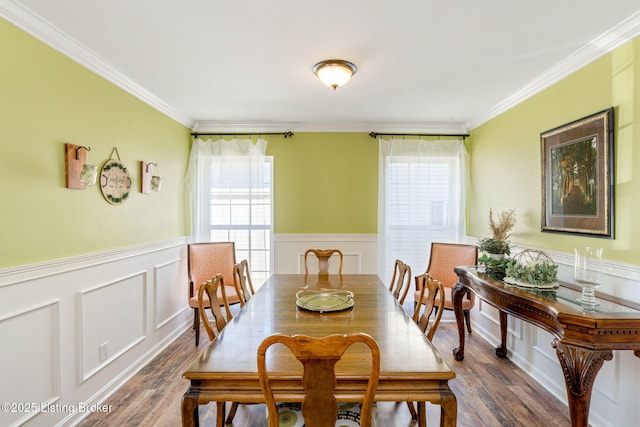 dining room featuring dark wood-style floors, wainscoting, plenty of natural light, and crown molding