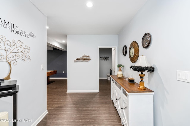 hallway featuring baseboards, dark wood finished floors, and recessed lighting