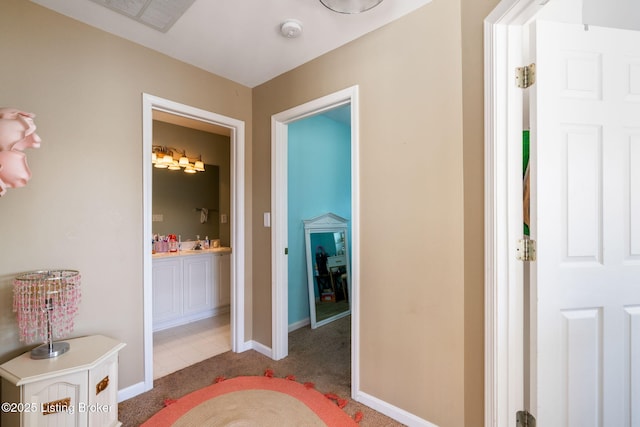 hall featuring carpet, visible vents, and baseboards