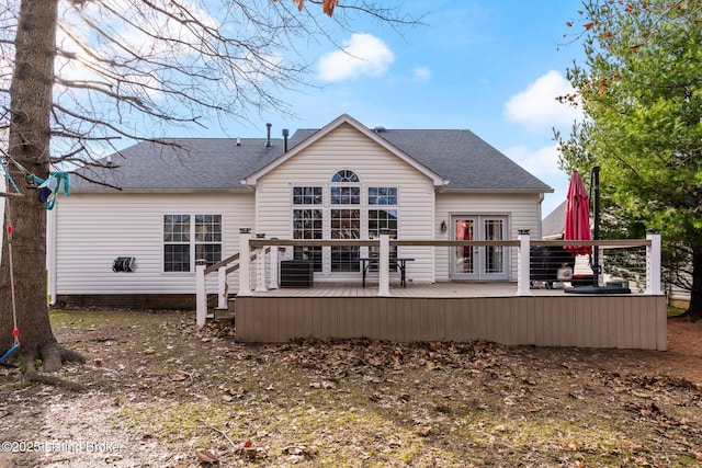 rear view of property featuring french doors, roof with shingles, and a wooden deck