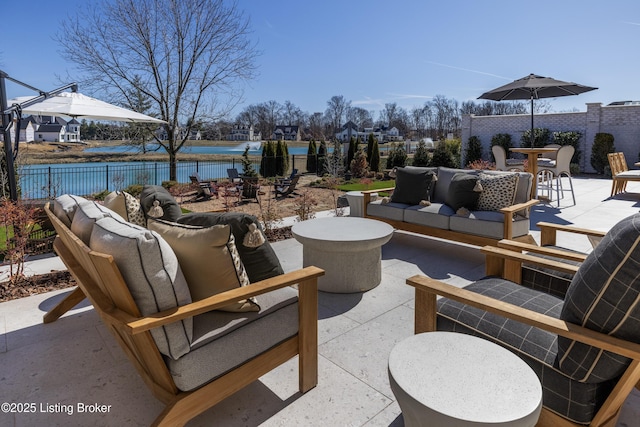 view of patio / terrace with outdoor dining area, outdoor lounge area, a water view, and a fenced backyard