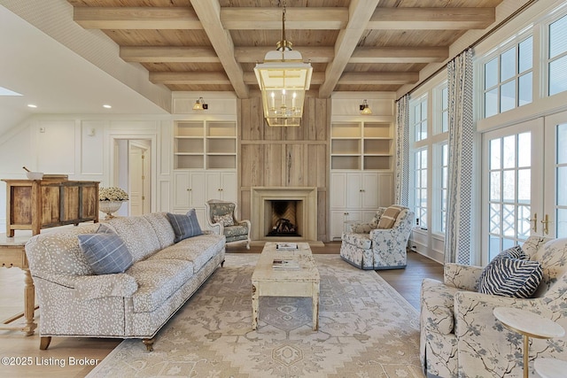 living area with wood ceiling, built in features, wood finished floors, and french doors