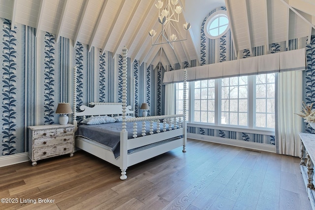 bedroom featuring a notable chandelier, vaulted ceiling, and wood finished floors