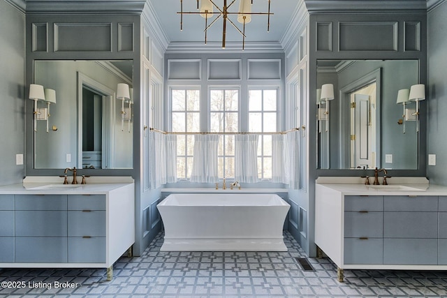 full bath with ornamental molding, two vanities, and a sink