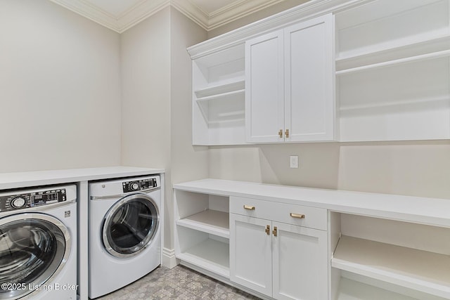 laundry room with cabinet space, crown molding, and washer and clothes dryer